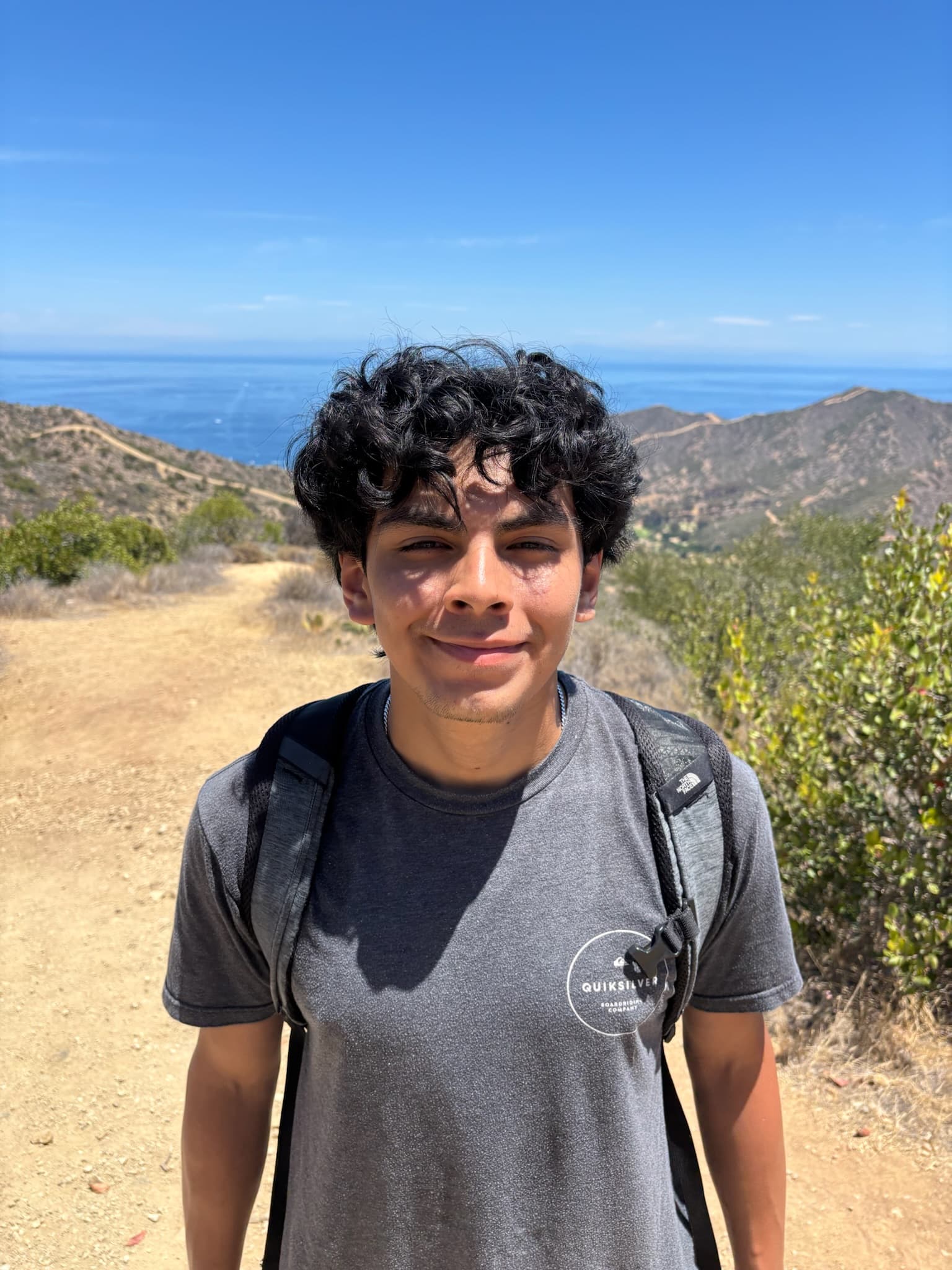 John Quevedo hiking on a mountain trail.